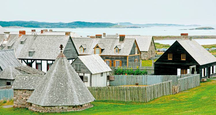 Pueblo histórico con edificios de madera cerca del mar.