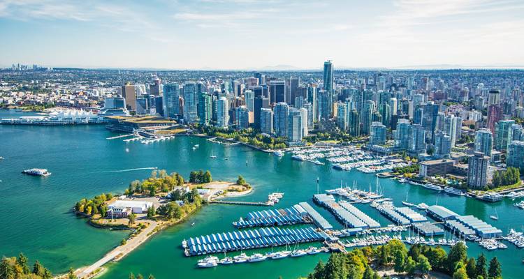 Luftaufnahme von Vancouver mit Gebäuden, Wasser und Bergen.