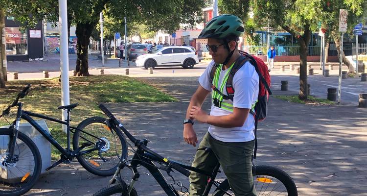 Personne portant un casque debout à côté d'un vélo.