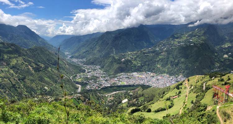 Vue large d'une vallée avec une ville entourée de montagnes.