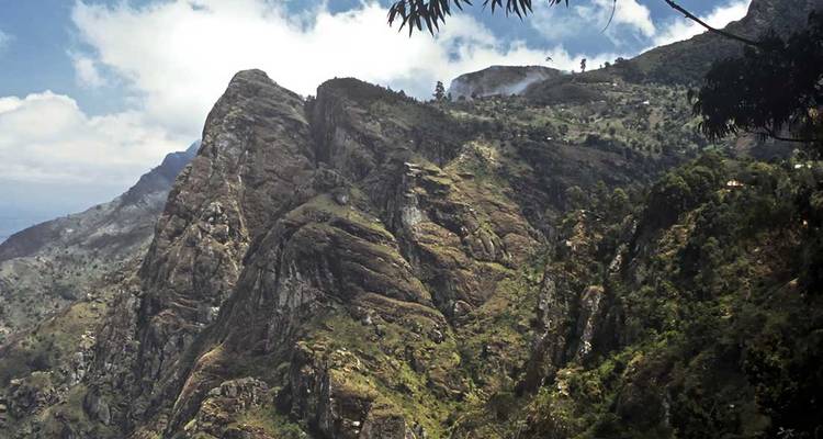 Mountainous terrain with steep peaks and vegetation.