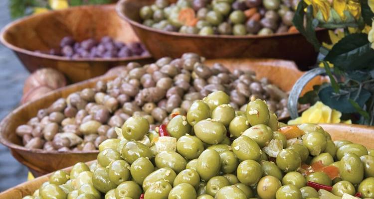 Gros plan de différents types d'olives dans des bols.