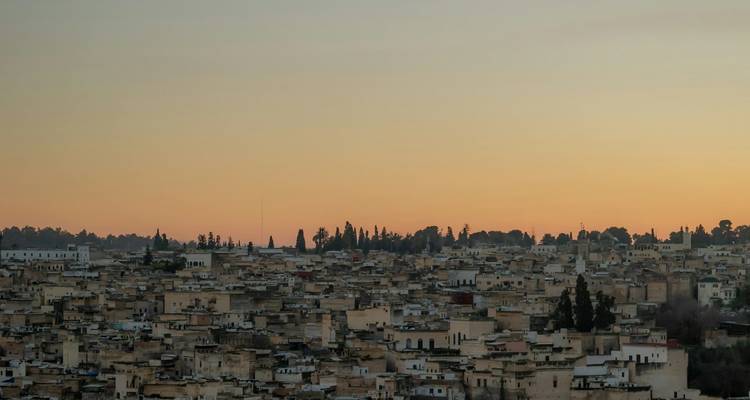 Paysage urbain de Fès sous un ciel de coucher de soleil.