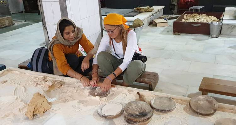 Deux femmes préparant du pain dans un cadre traditionnel.