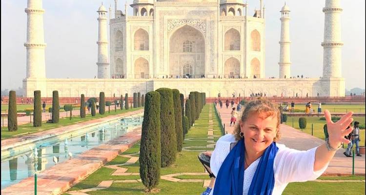 Femme posant devant le Taj Mahal avec le bras tendu.