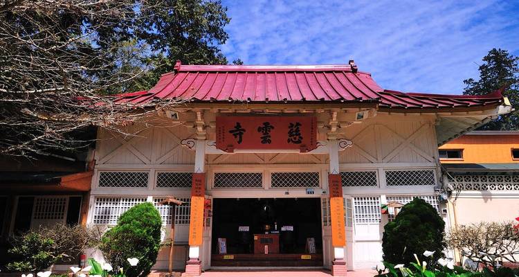 Temple traditionnel avec toit rouge et entrée décorative.