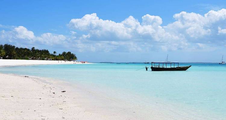 Lonely boat on a pristine tropical beach with turquoise water.