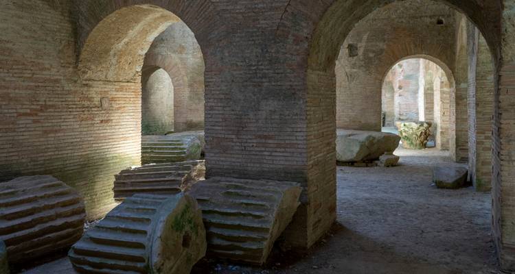 Chambres souterraines en brique avec des colonnes effondrées.
