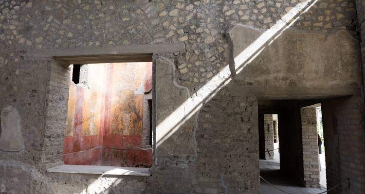 Lumière du soleil illuminant des murs ornés de fresques anciennes.