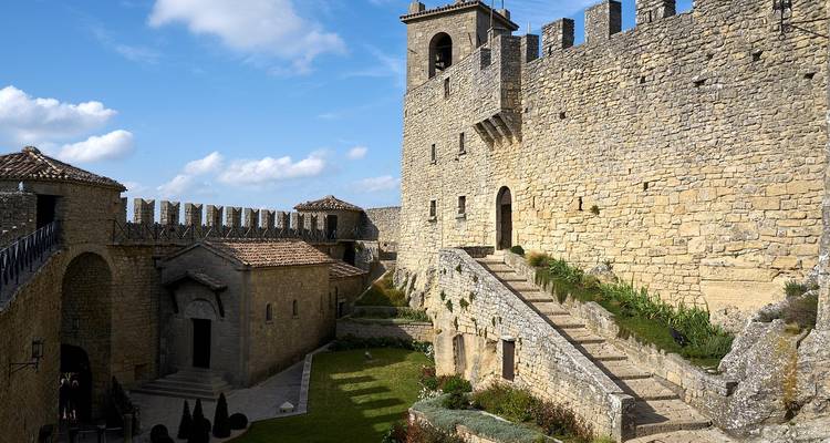 Stone fortification with steps and battlements under clear skies.