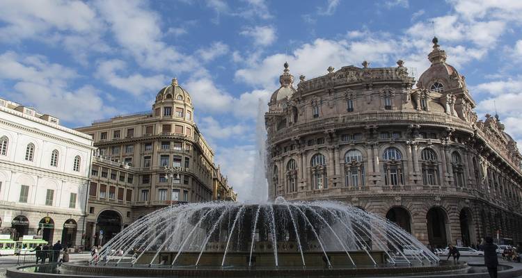 Urban square with a large fountain and historic buildings.