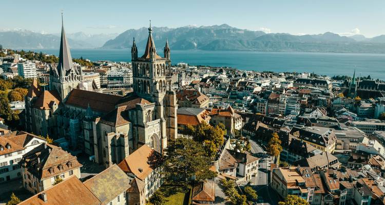 Vue aérienne de Lausanne avec une cathédrale et un lac.