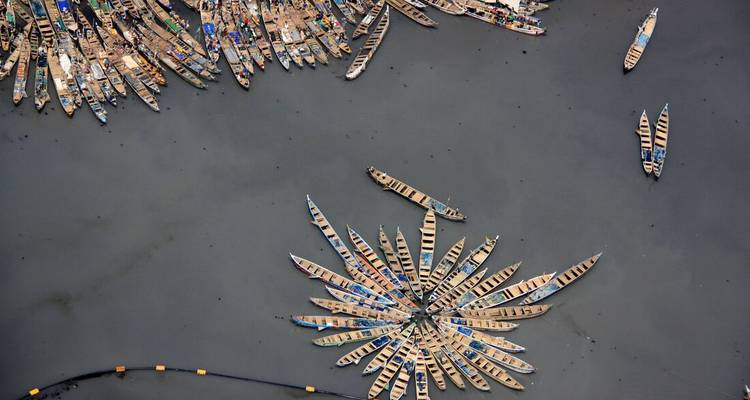 Aerial view of numerous boats assembled on water.