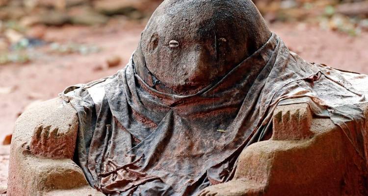 Stone sculpture draped with cloth.