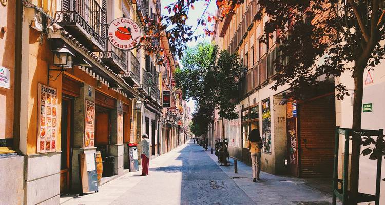 Quiet street scene with colorful buildings and trees.