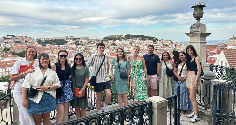 Groupe de personnes dominant une ville avec une vue emblématique.