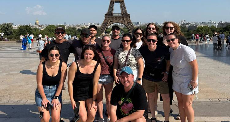 Groupe de personnes posant devant la Tour Eiffel.