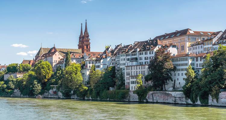 Scenic view of Basel's riverside with historical buildings.