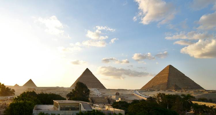 Vue panoramique des pyramides dans le désert avec un ciel bleu dégagé.