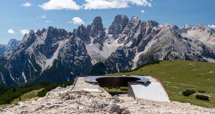 Runde Aussichtsplattform mit Blick auf eine dramatische Bergkette.