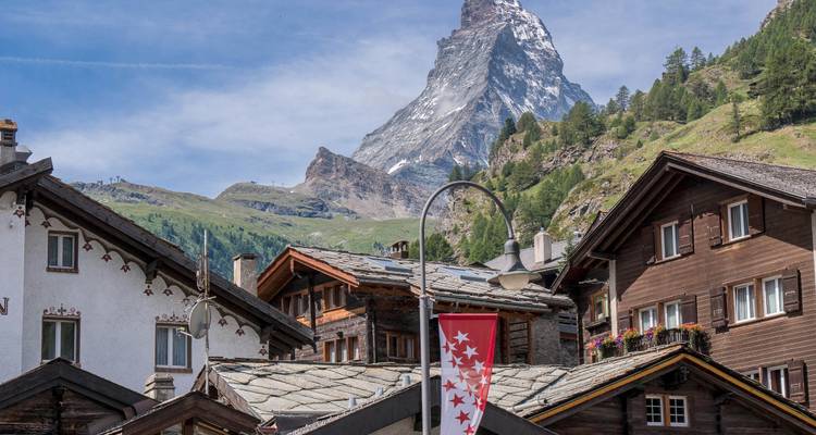 Une vue de maisons suisses traditionnelles avec le Cervin en arrière-plan.
