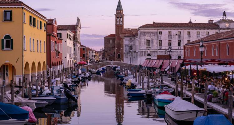 Canal pittoresque avec des bâtiments colorés et des bateaux, ressemblant à Venise.