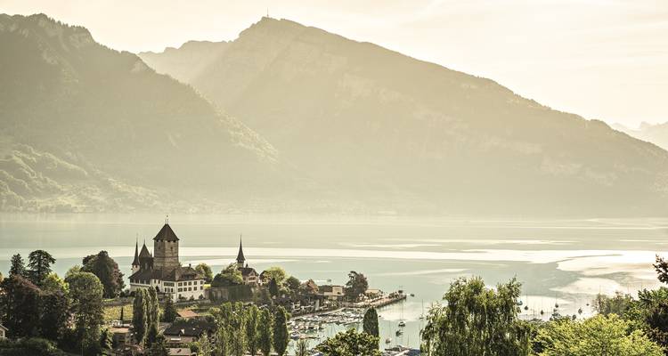 Vue au coucher du soleil d'une ville au bord du lac avec des montagnes.