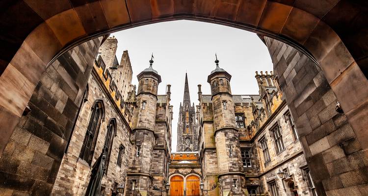 Sierlijk gotisch gebouw gezien door een grote boog.
