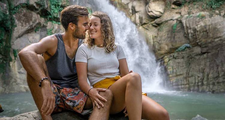 Couple assis près d'une cascade profitant d'un moment ensemble.