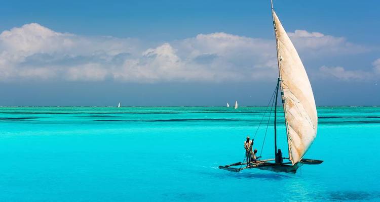 Un voilier traditionnel dans des eaux turquoise éclatantes sous un ciel dégagé.
