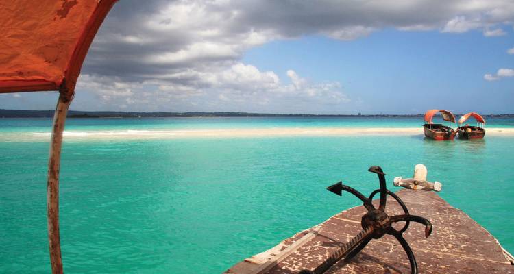 Une plage pittoresque avec une eau turquoise claire et des bateaux en bois.