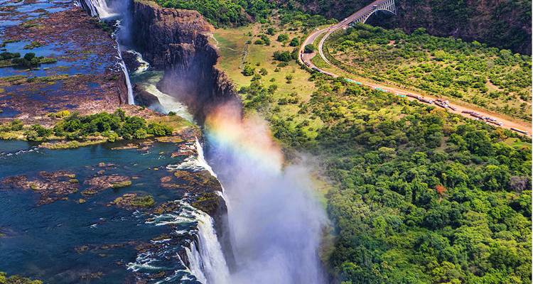 Aerial view of Victoria Falls with a visible rainbow.