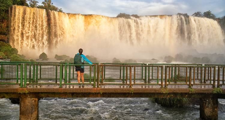 Personne debout sur une plateforme près d'une cascade.