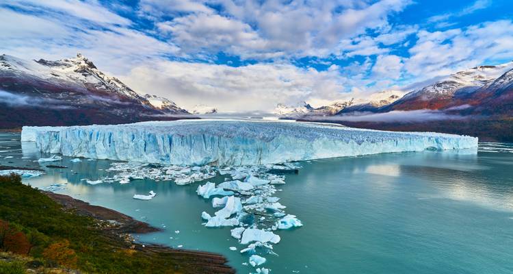 Vue panoramique du glacier Perito Moreno entouré de montagnes.