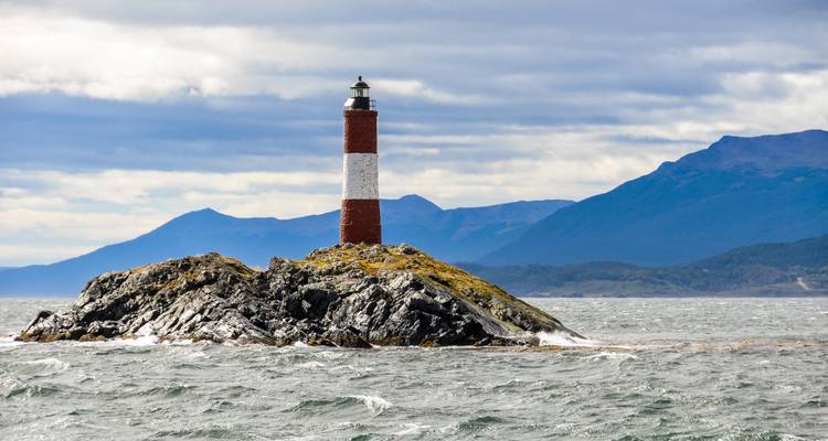 Phare sur une île rocheuse au milieu de l'océan.