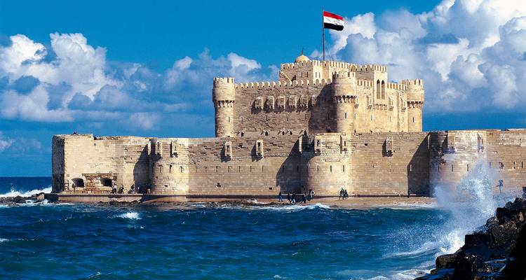 Fortaleza junto al mar con una bandera ondeando en la cima.