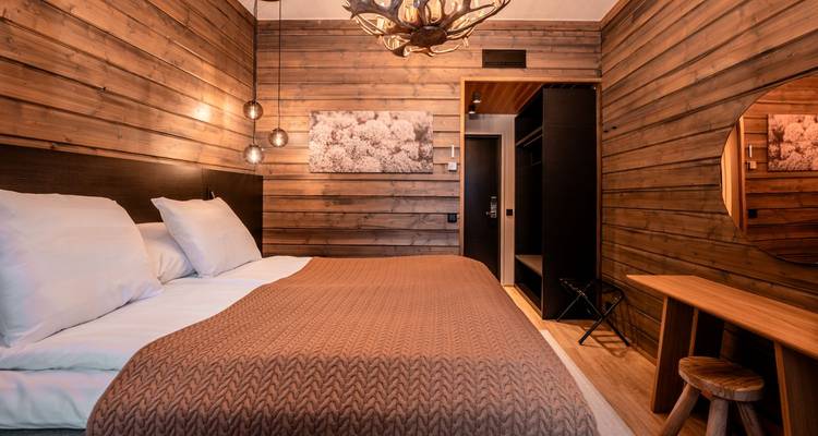Warmly lit wooden bedroom interior with rustic decor.