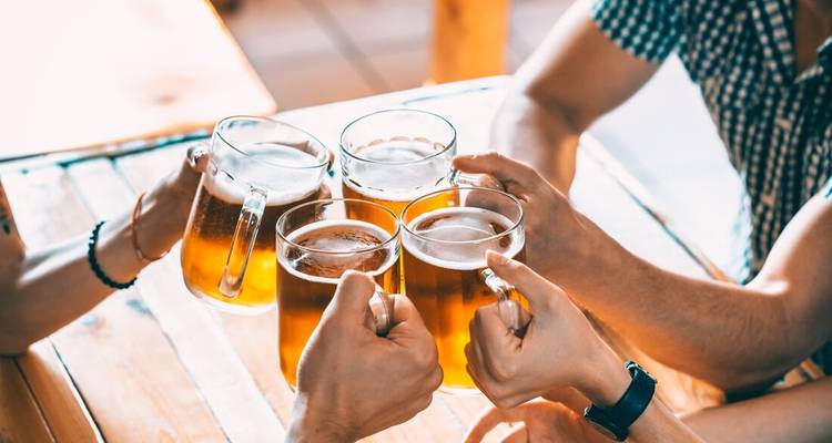 Groupe de personnes qui trinquent avec des chopes de bière.
