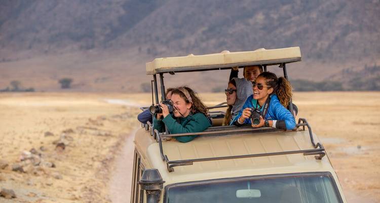Groupe sur un véhicule de safari observant la faune.