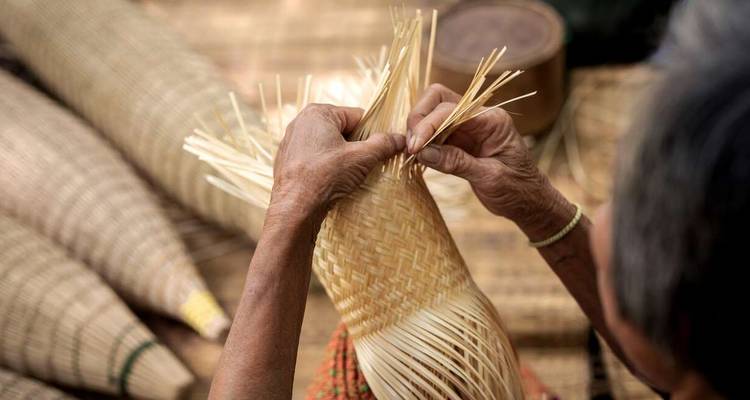 Gros plan sur des mains tressant des paniers traditionnels