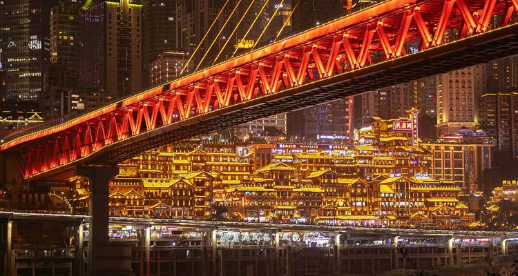 Bridge and illuminated cityscape at night.