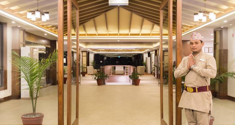 Persona en vestimenta tradicional dando la bienvenida en la entrada del hotel.
