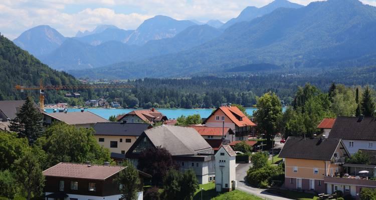 Pueblo con tejados y vista lejana de montañas y lago.