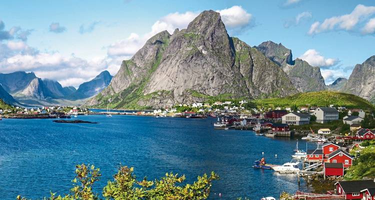 Schilderachtig uitzicht op bergen en een kustdorp met boten.