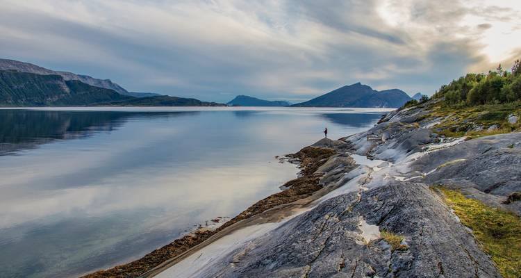 Un lago tranquilo rodeado de paisajes rocosos y colinas.