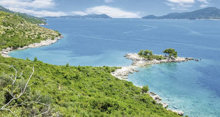 Baie pittoresque avec une eau turquoise et une végétation luxuriante.