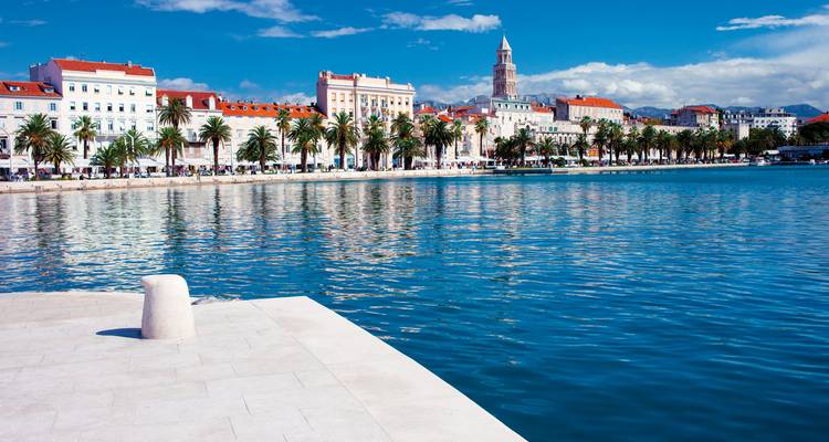 Vue sur le front de mer avec bâtiments historiques et promenade.