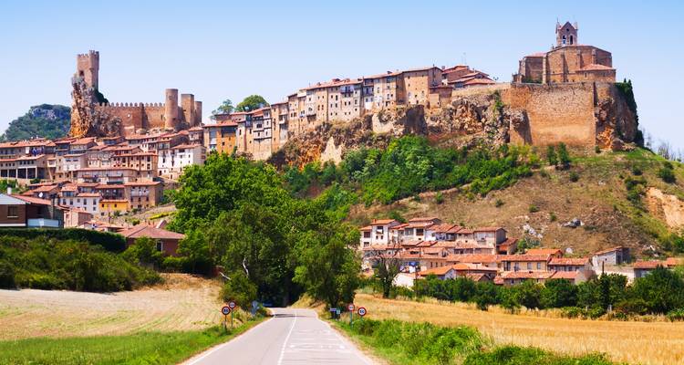 Vue panoramique de Frías avec un château médiéval et un village sur une colline.