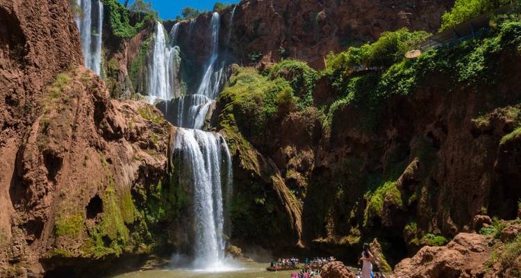 Une cascade pittoresque entourée d'une végétation luxuriante et de formations rocheuses.