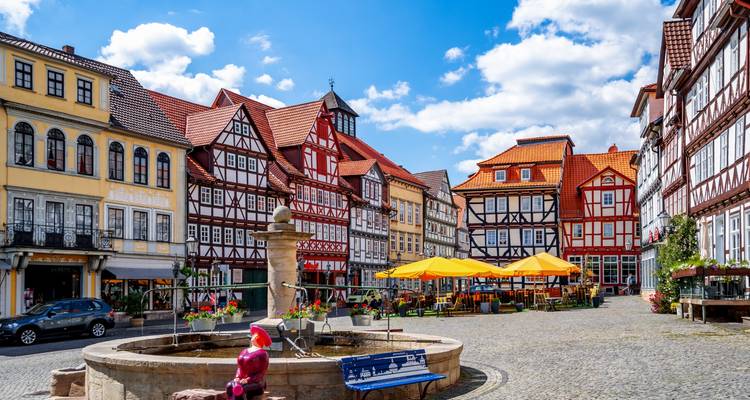Vibrant square with half-timbered houses and outdoor seating.
